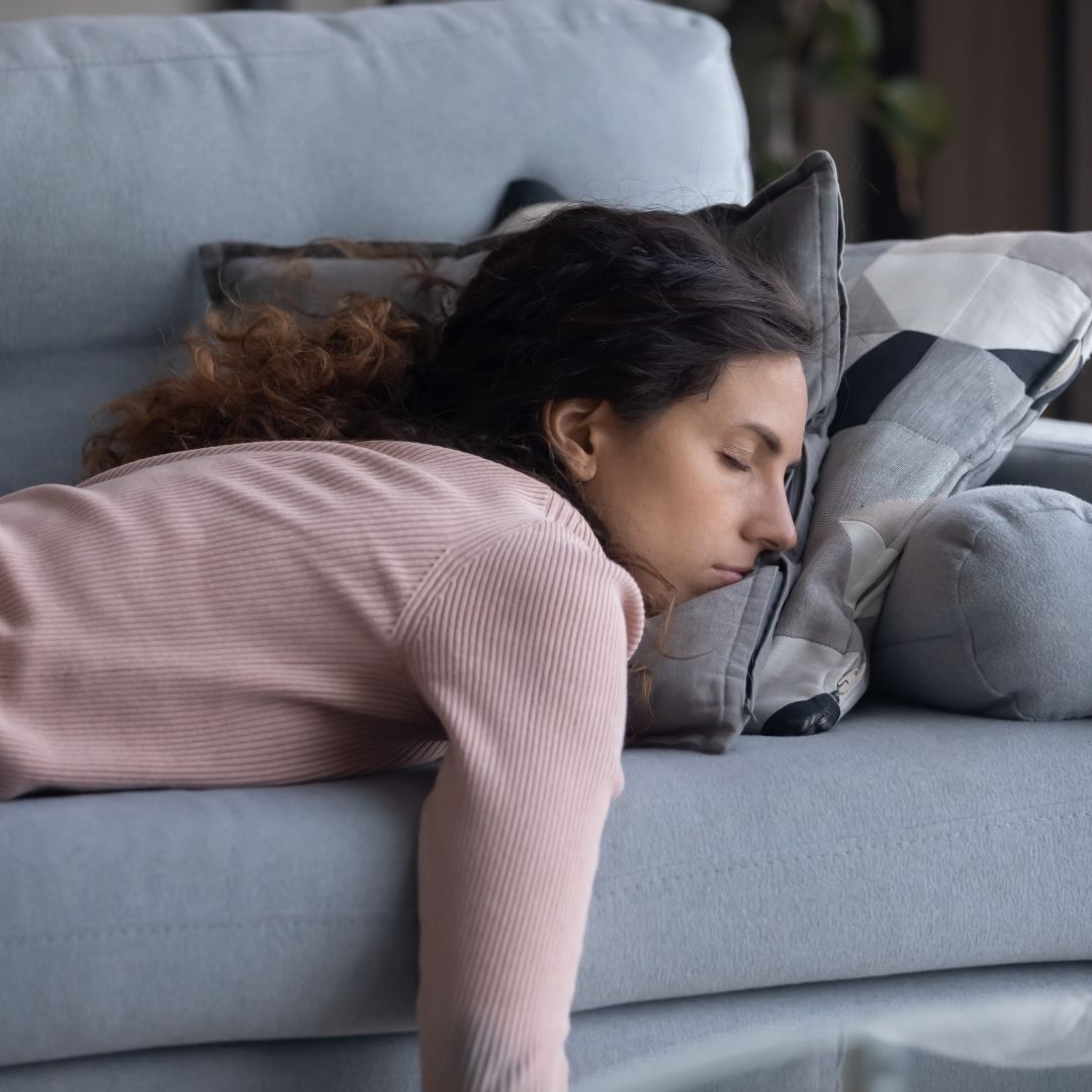 Woman lying awake feeling tired after disrupted sleep, representing sleep apnoea symptoms associated with PMOS.
